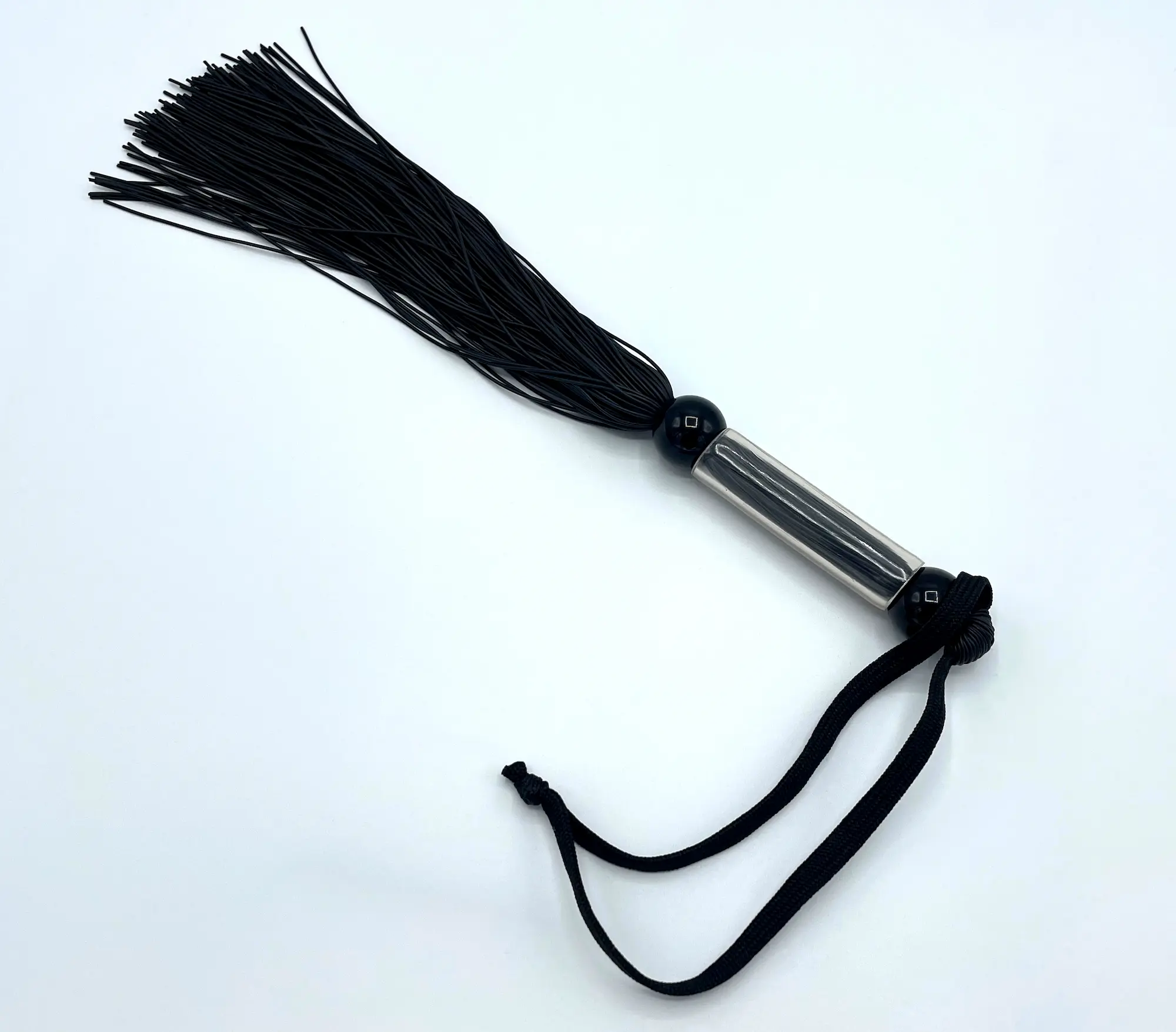 Schwarze Genitalpeitsche mit flexiblen Silikonriemen und rutschfestem Griff, ca. 27 cm lang, für gezielte Reize im Intimbereich.