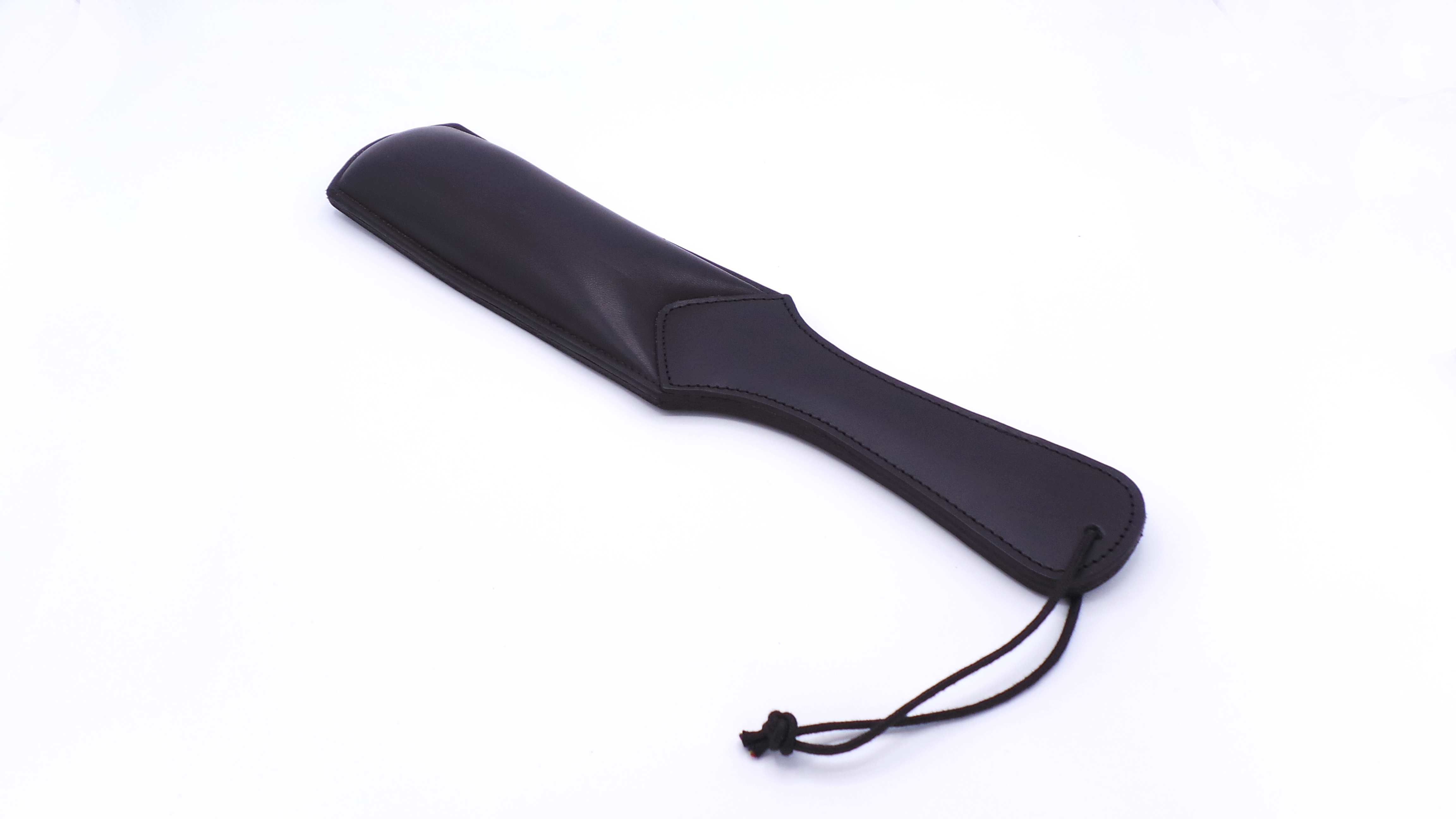 Gepolstertes Lederpaddel – 37 cm, kompakt und intensiv Schwarzes gepolstertes Lederpaddel mit ca. 37 cm Länge und breiter Schlagfläche, inklusive Handschlaufe für sicheren Halt.